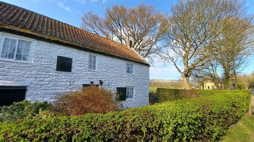 George Stephenson's Birthplace Cottage surrounds by wintery trees